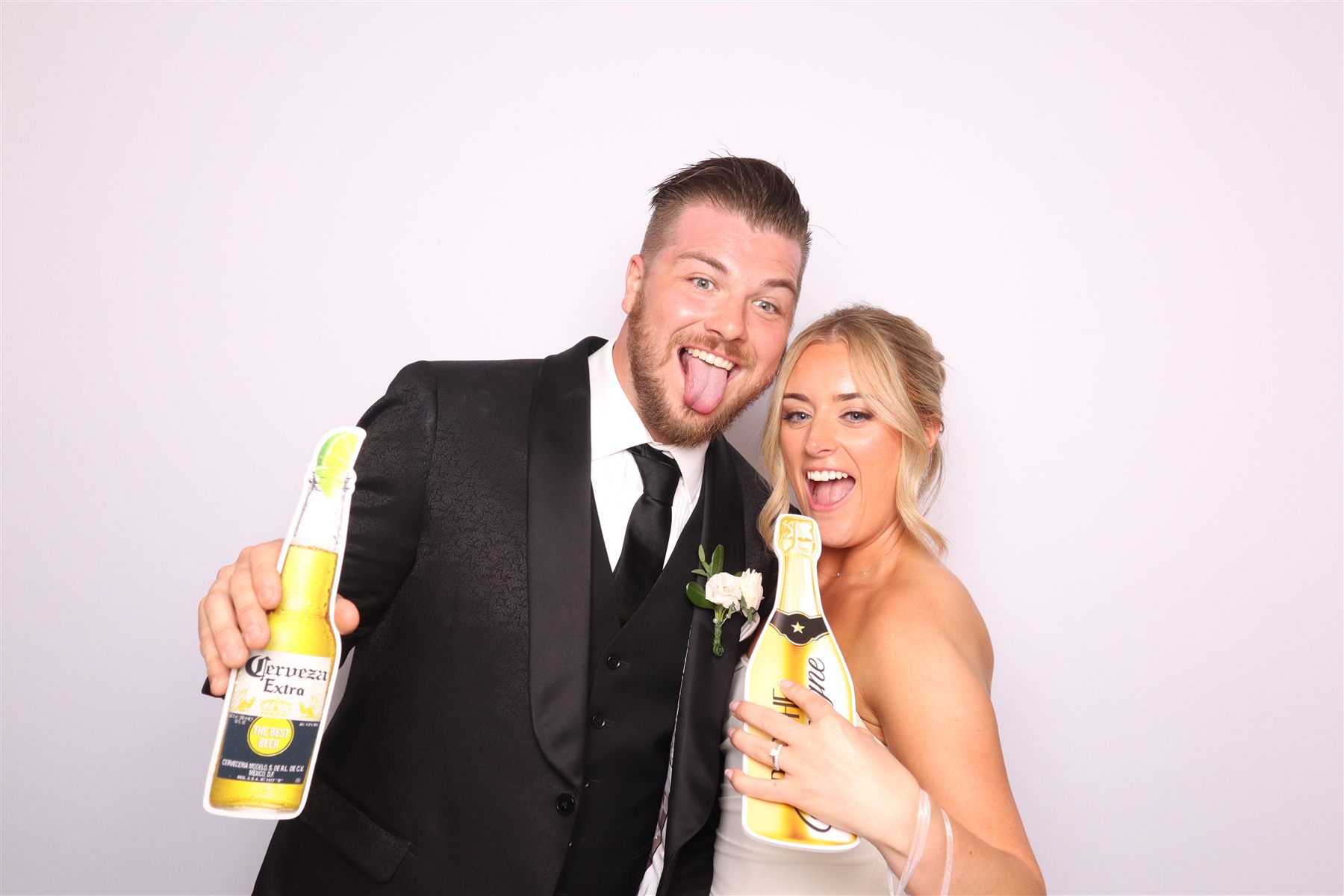 Newlyweds posing with props in the photobooth